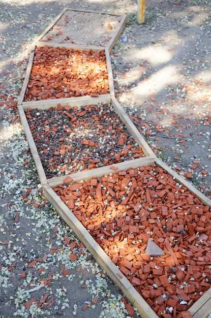 В зависимости от условий эксплуатации и предпочтений, можно комбинировать материалы. Например, уютную зону из деревянной мульчи дополнить каменными вставками, а для обустройства основных путей – использовать крупнозернистый щебень. Такой подход позволяет добиться долговечности поверхности и минимизировать уход за ней. Важно при этом продумать дренаж и способ очистки, чтобы избежать накопления грязи и растений на межслойных соединениях.